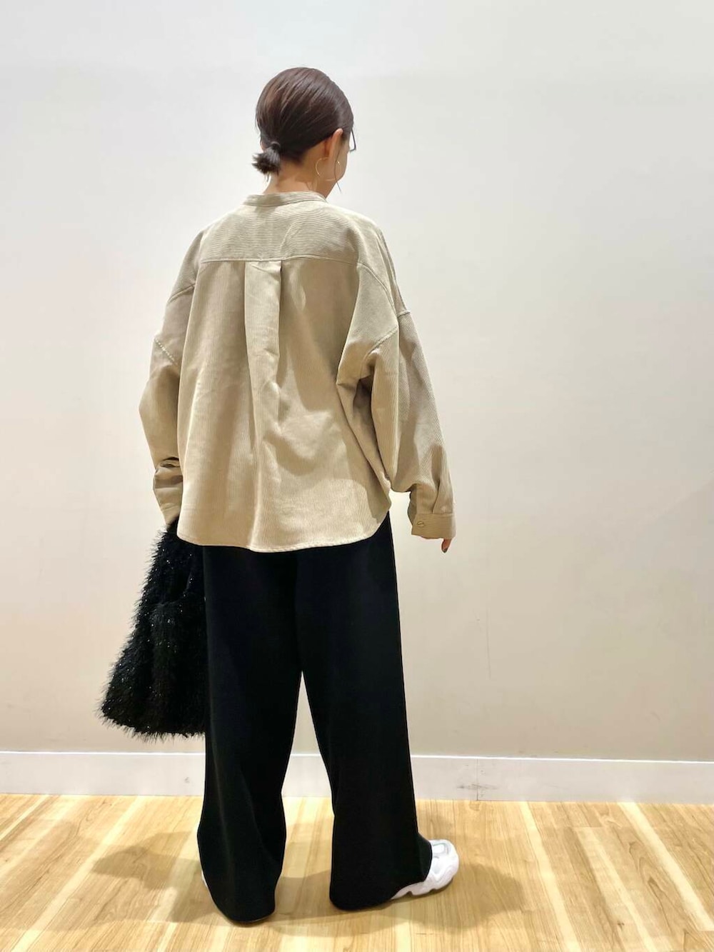 ホワイト系のスニーカー、ベージュ系のTシャツ/カットソー、ブラック系のダウンジャケット/コートを着用したレディースの冬コーディネートの8枚目の写真