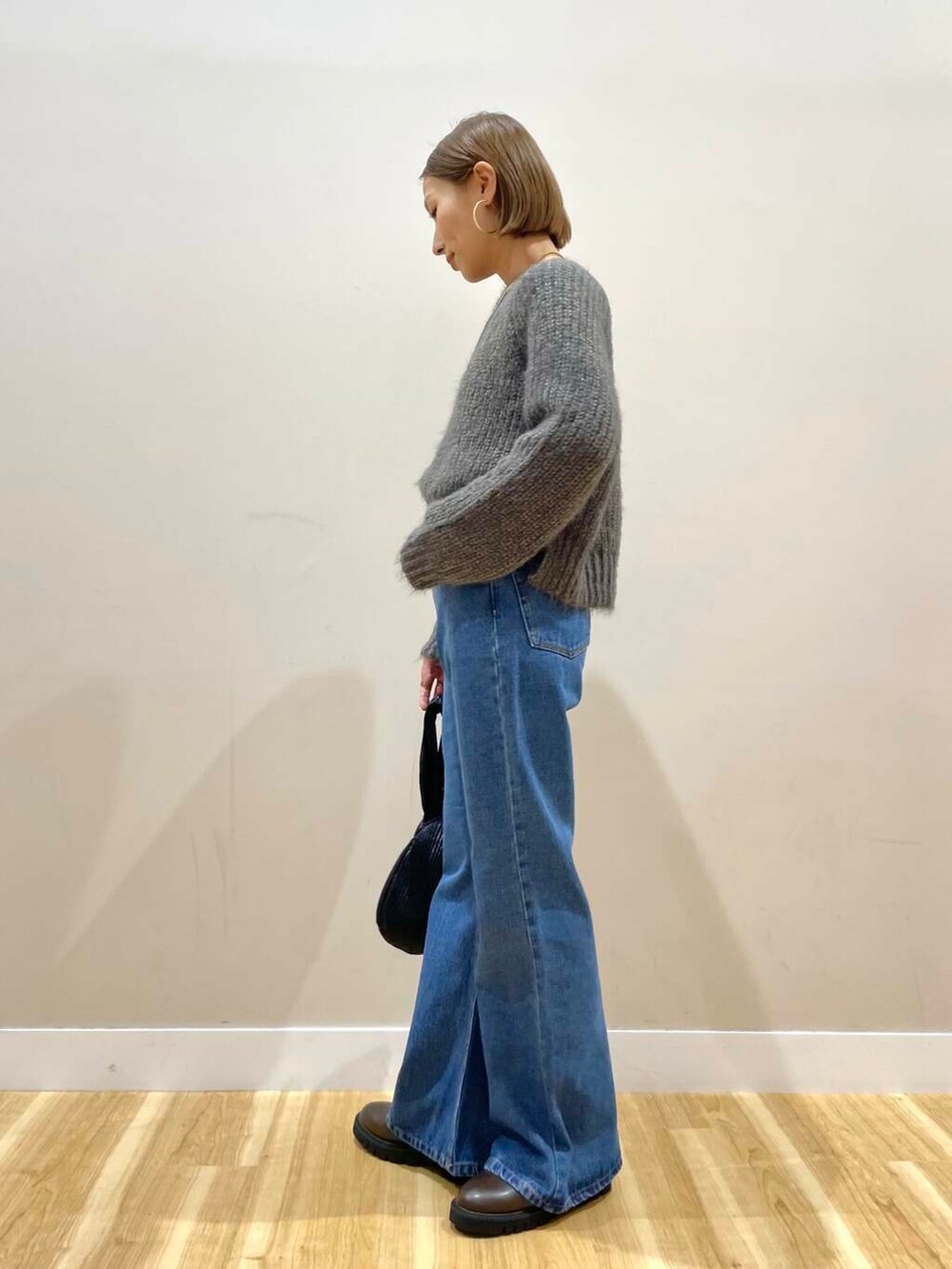 ブラウン系のブーツ、ブルー系のデニムパンツ、ブラック系のハンドバッグを着用したレディースの秋コーディネートの9枚目の写真