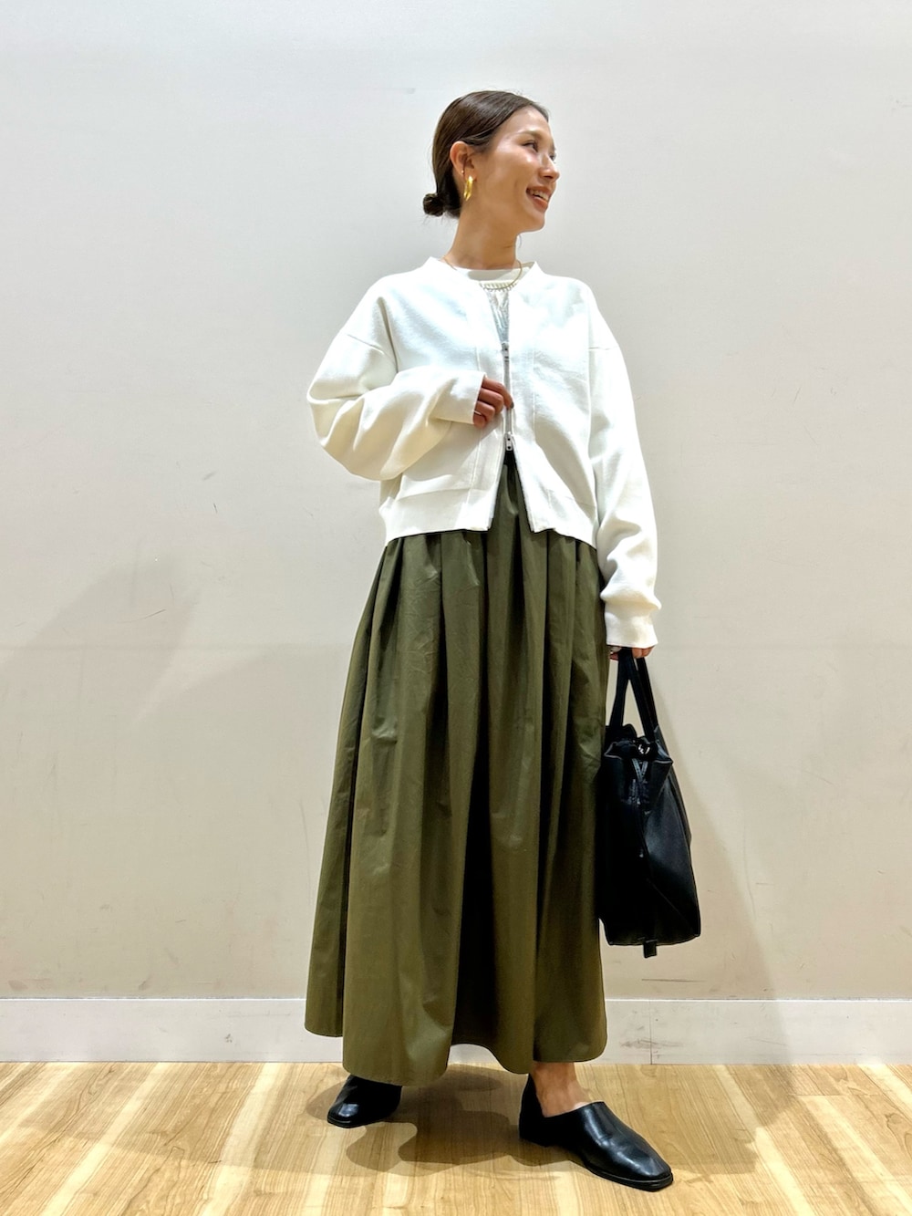 ホワイト系のカーディガン/ボレロ、ホワイト系のニット/セーター、グリーン系のスカートを着用したレディースの春コーディネートの7枚目の写真