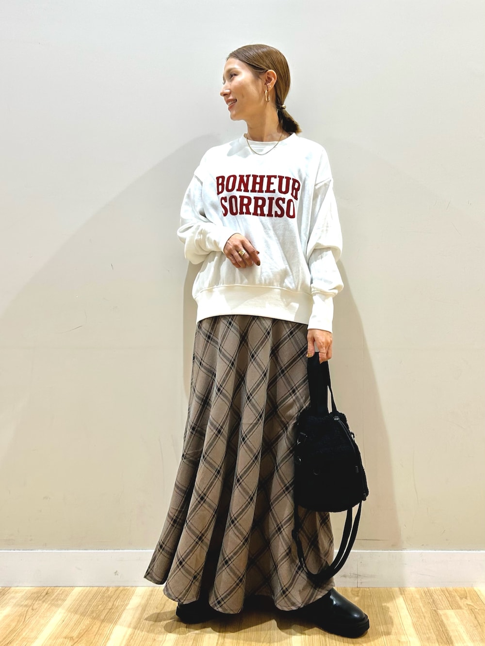 ブラック系のデニムジャケット、ホワイト系のスウェット、ブラウン系のスカートを着用したレディースの秋コーディネートの4枚目の写真