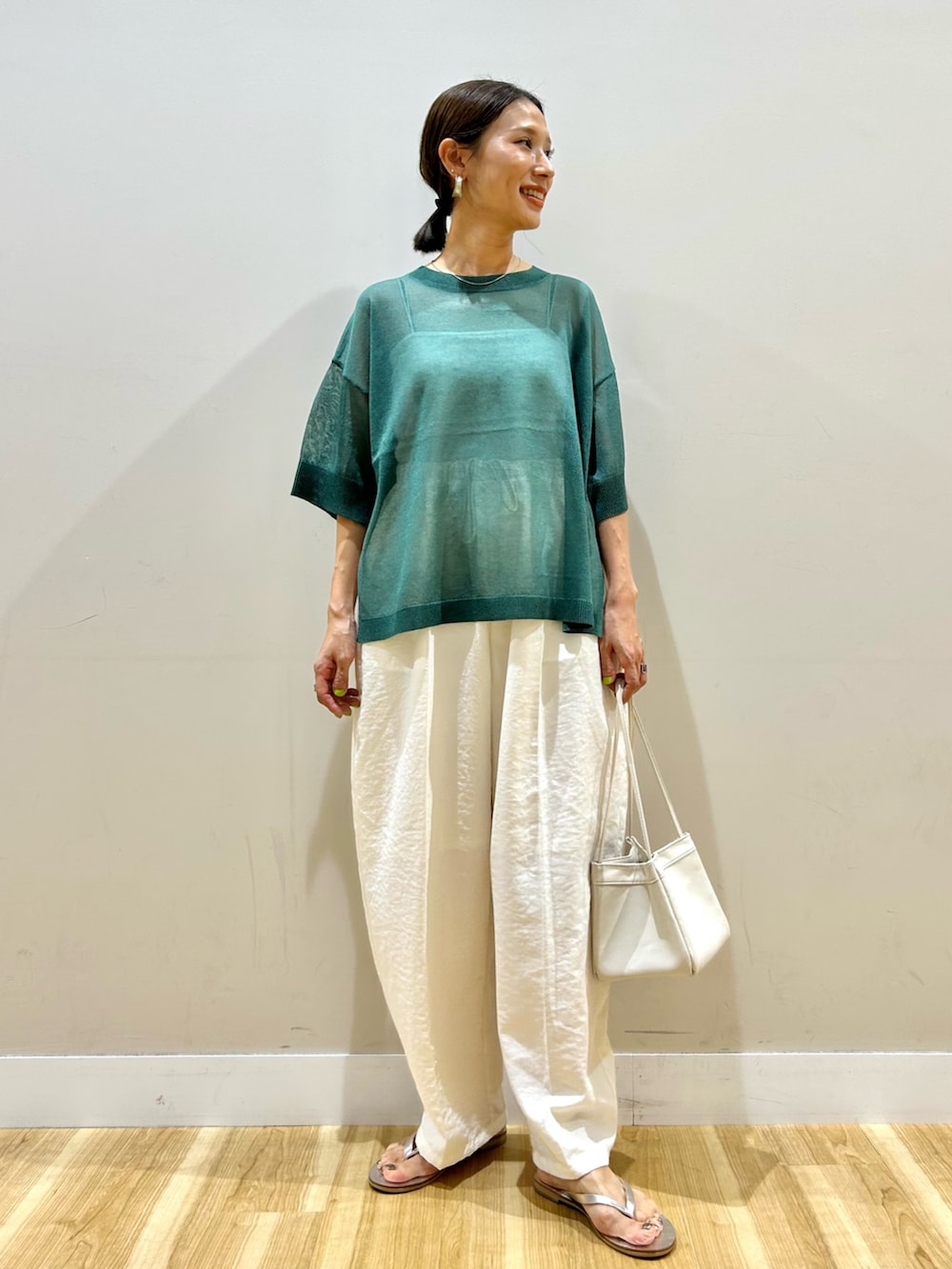 グリーン系のニット/セーター、ホワイト系のその他パンツを着用したレディースの夏コーディネートの2枚目の写真