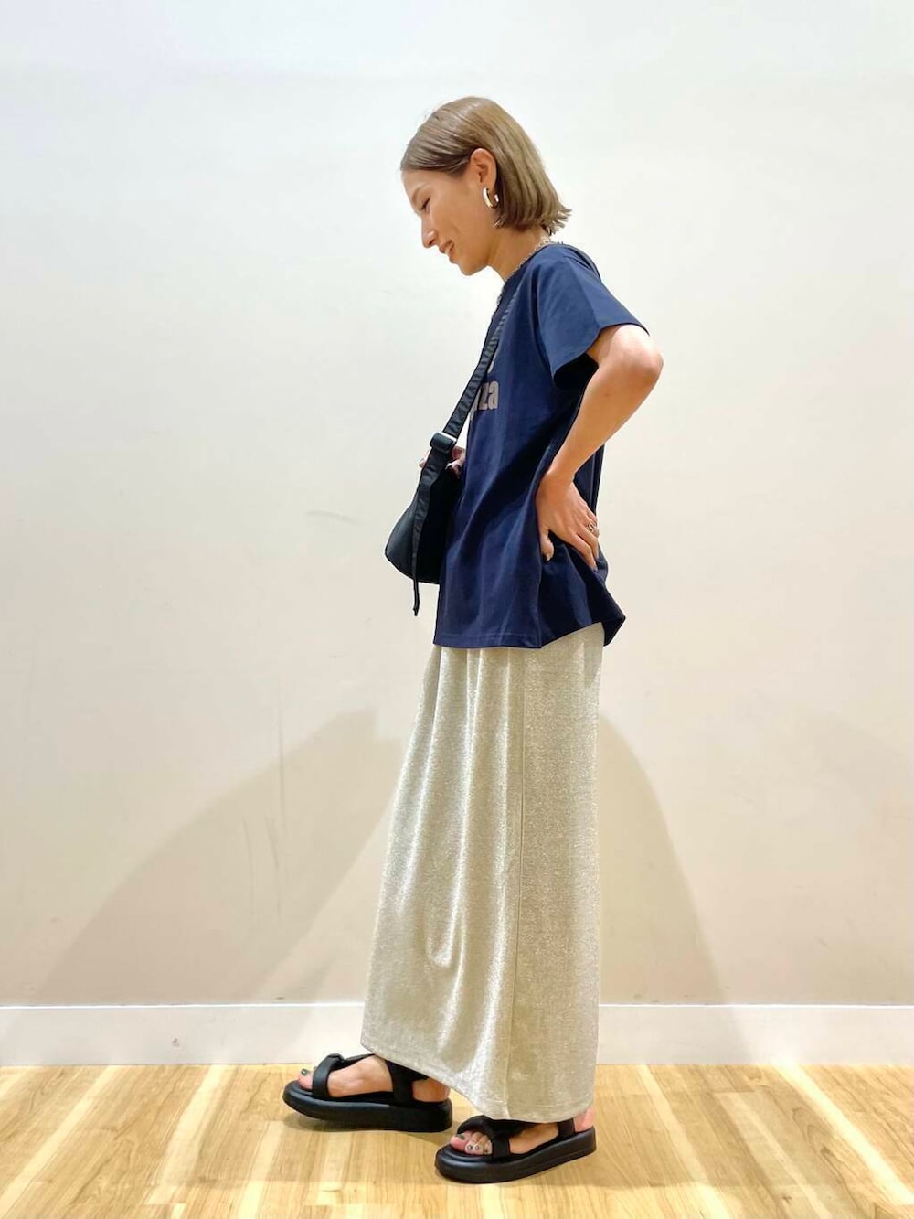 ブラック系のショルダーバッグ、ブラック系のサンダル、ブルー系のTシャツ/カットソーを着用したレディースの夏コーディネートの2枚目の写真