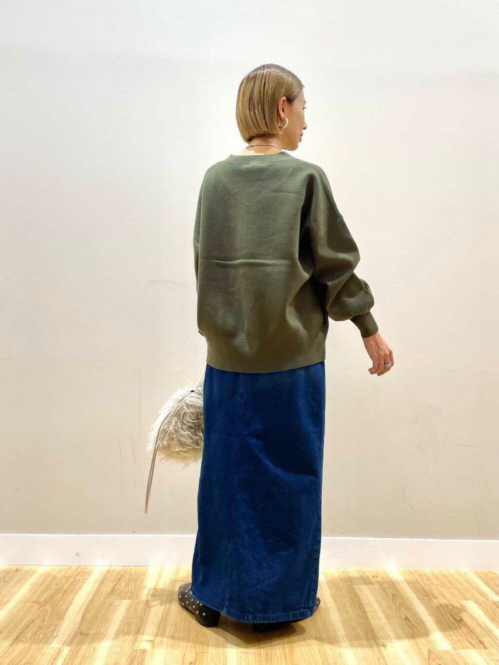 ベージュ系のショルダーバッグ、ブラック系のパンプス、ブルー系のスカートを着用したレディースの秋コーディネートの4枚目の写真