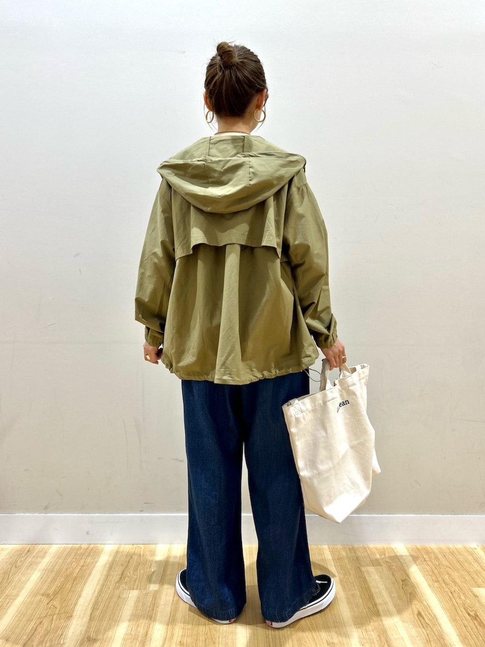 ベージュ系のマウンテンパーカー、ホワイト系のニット/セーター、ブルー系のその他パンツを着用したレディースの春コーディネートの4枚目の写真