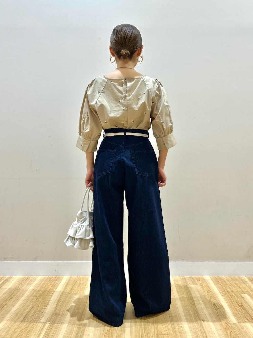 ベージュ系のシャツ/ブラウス、ブルー系のデニムパンツ、ホワイト系のハンドバッグを着用したレディースの春コーディネートの4枚目の写真