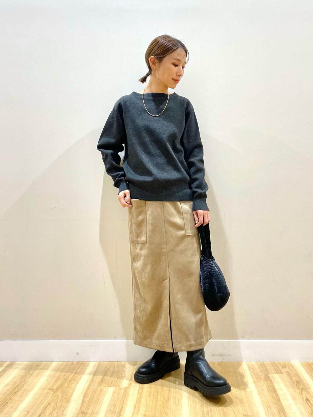 ホワイト系のダウンジャケット/コート、グレー系のニット/セーター、ブラウン系のスカートを着用したレディースの冬コーディネートの5枚目の写真