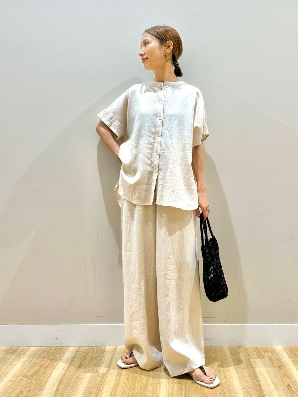 ベージュ系のその他パンツ、ベージュ系のシャツ/ブラウス、ブラック系のショルダーバッグを着用したレディースの夏コーディネートの5枚目の写真