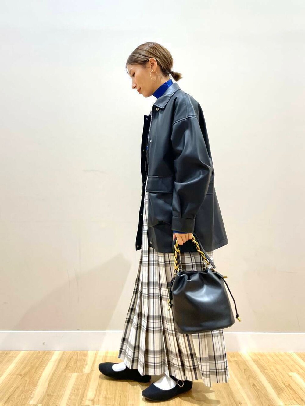 ブラック系のショルダーバッグ、ブラック系のその他アウター、ブルー系のニット/セーターを着用したレディースの冬コーディネートの2枚目の写真