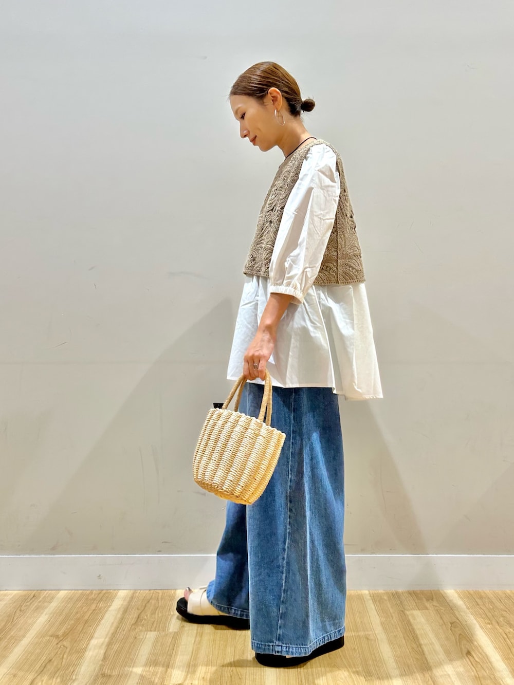 ベージュ系のシャツ/ブラウス、グレー系のハンドバッグ、ホワイト系のサンダルを着用したレディースの夏コーディネートの3枚目の写真