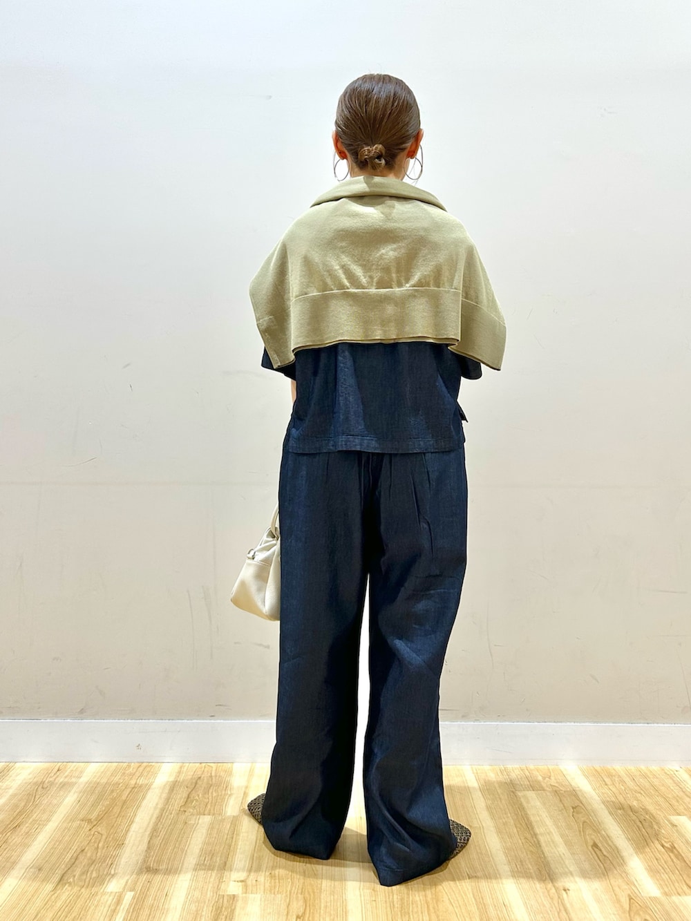 ホワイト系のTシャツ/カットソー、ブルー系のデニムパンツ、ブラウン系のハンドバッグを着用したレディースの春コーディネートの3枚目の写真