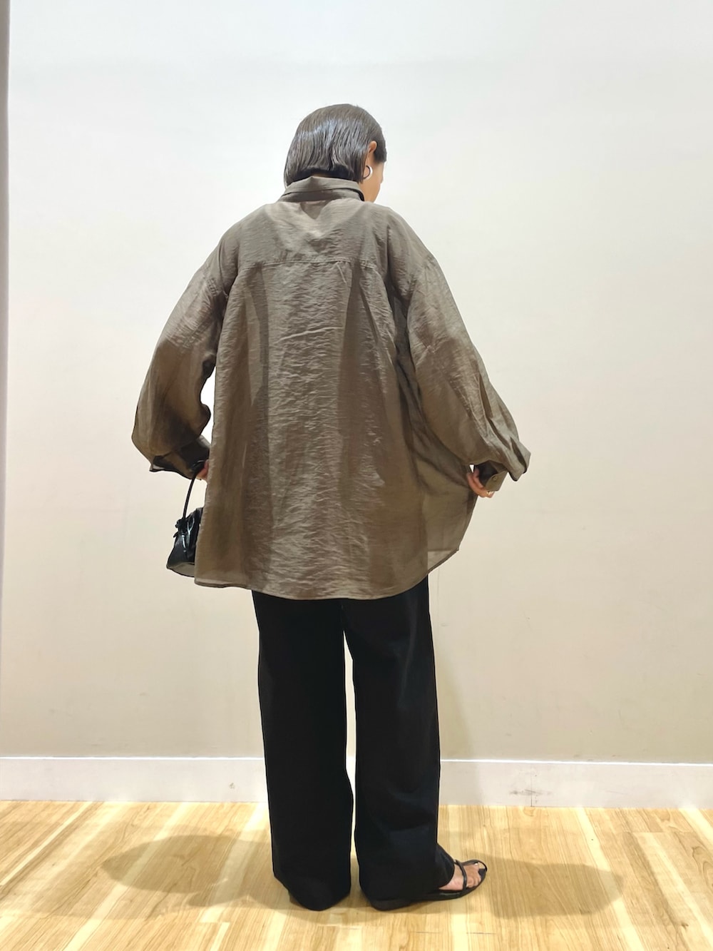 ブラウン系のシャツ/ブラウス、ブラック系のチノパンツ、ブラック系のタンクトップを着用したレディースの秋コーディネートの3枚目の写真