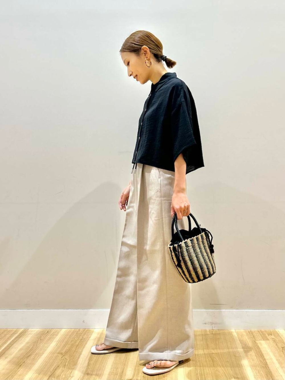 ブラック系のハンドバッグ、ブラック系のサンダル、ブラック系のシャツ/ブラウスを着用したレディースの夏コーディネートの2枚目の写真