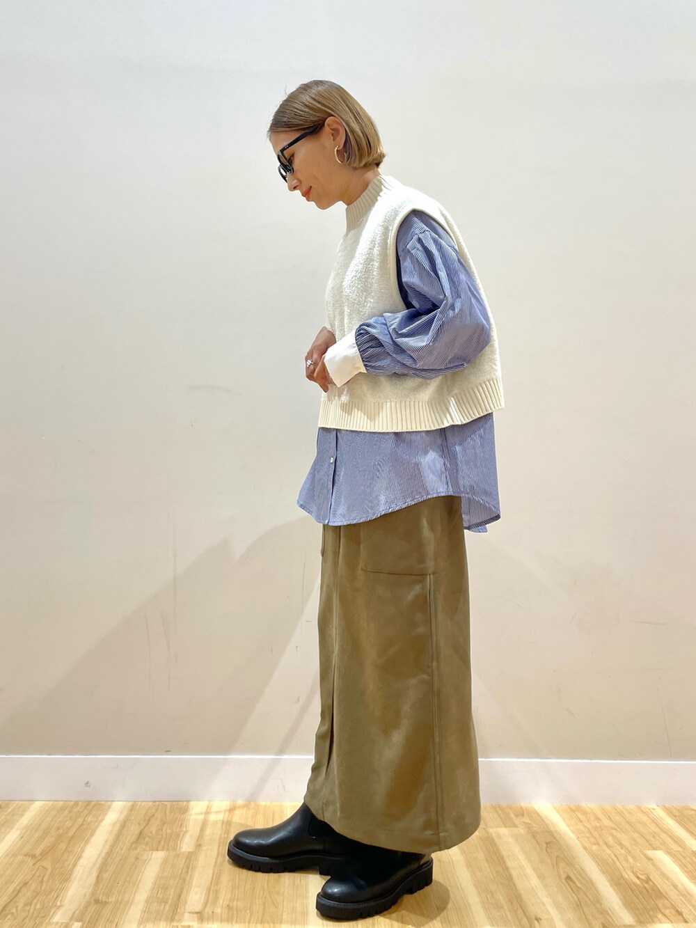 ホワイト系のニット/セーター、ブルー系のシャツ/ブラウス、グリーン系のスカートを着用したレディースの秋コーディネートの4枚目の写真