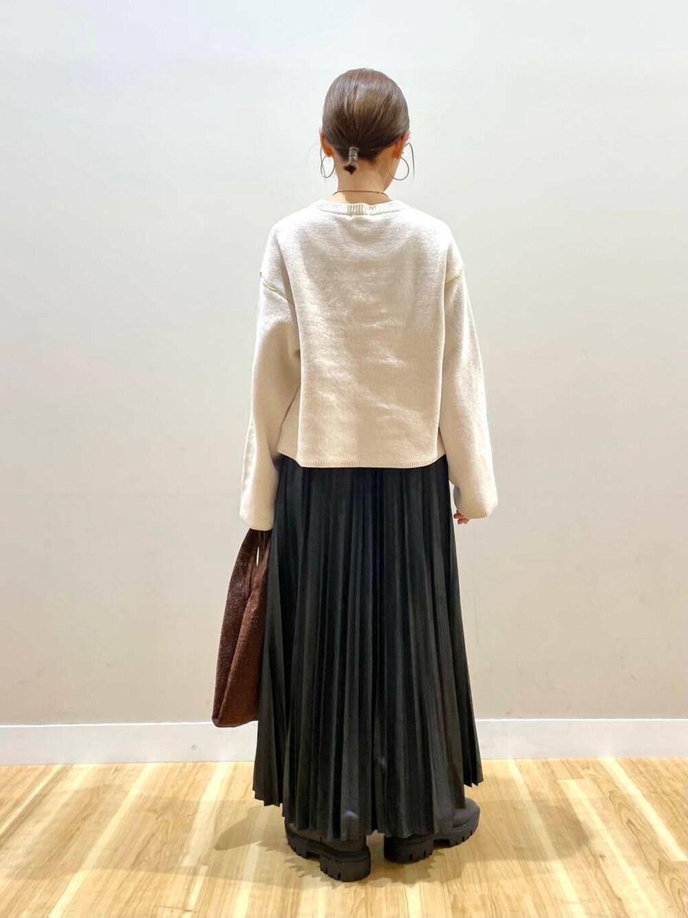 ブラック系のブーツ、ホワイト系のニット/セーター、ブラウン系のトートバッグを着用したレディースの冬コーディネートの7枚目の写真