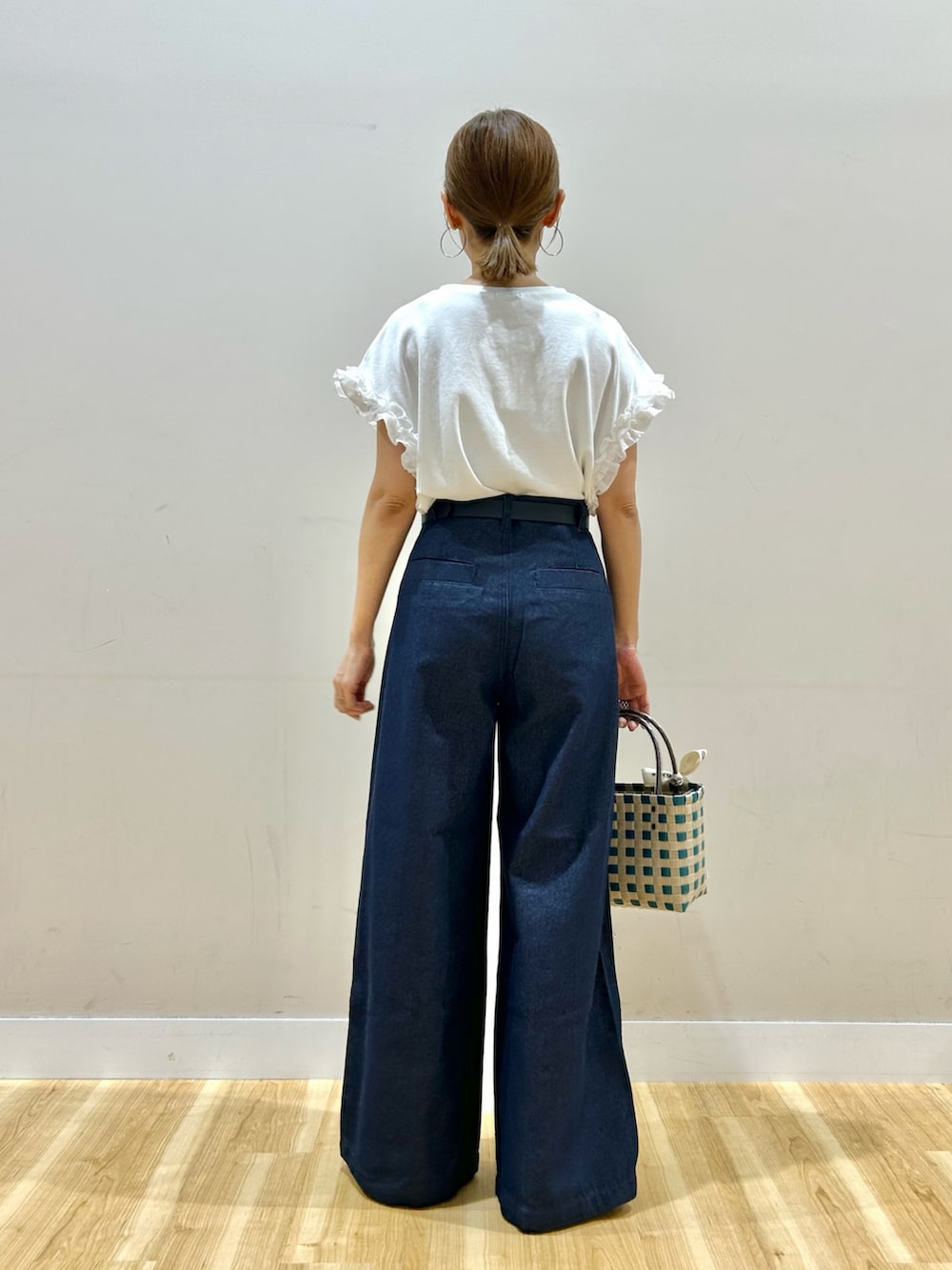 ホワイト系のTシャツ/カットソー、ブルー系のデニムパンツ、グリーン系のショルダーバッグを着用したレディースの夏コーディネートの3枚目の写真