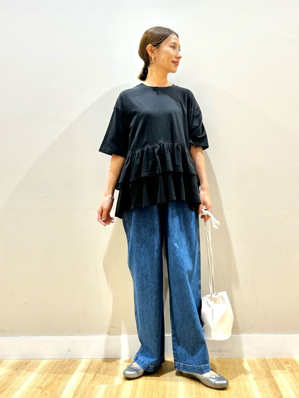 ブラック系のTシャツ/カットソー、ブルー系のデニムパンツ、ゴールド系のショルダーバッグを着用したレディースの秋コーディネートの4枚目の写真