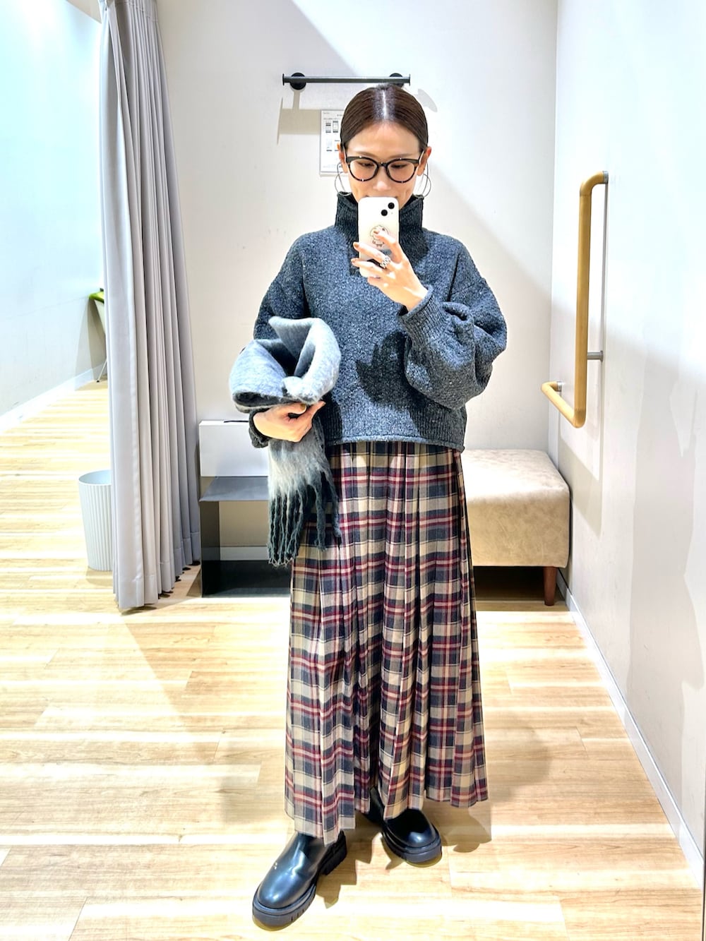 グレー系のニット/セーター、ブラウン系のスカート、ブラック系のブーツを着用したレディースの冬コーディネートの3枚目の写真