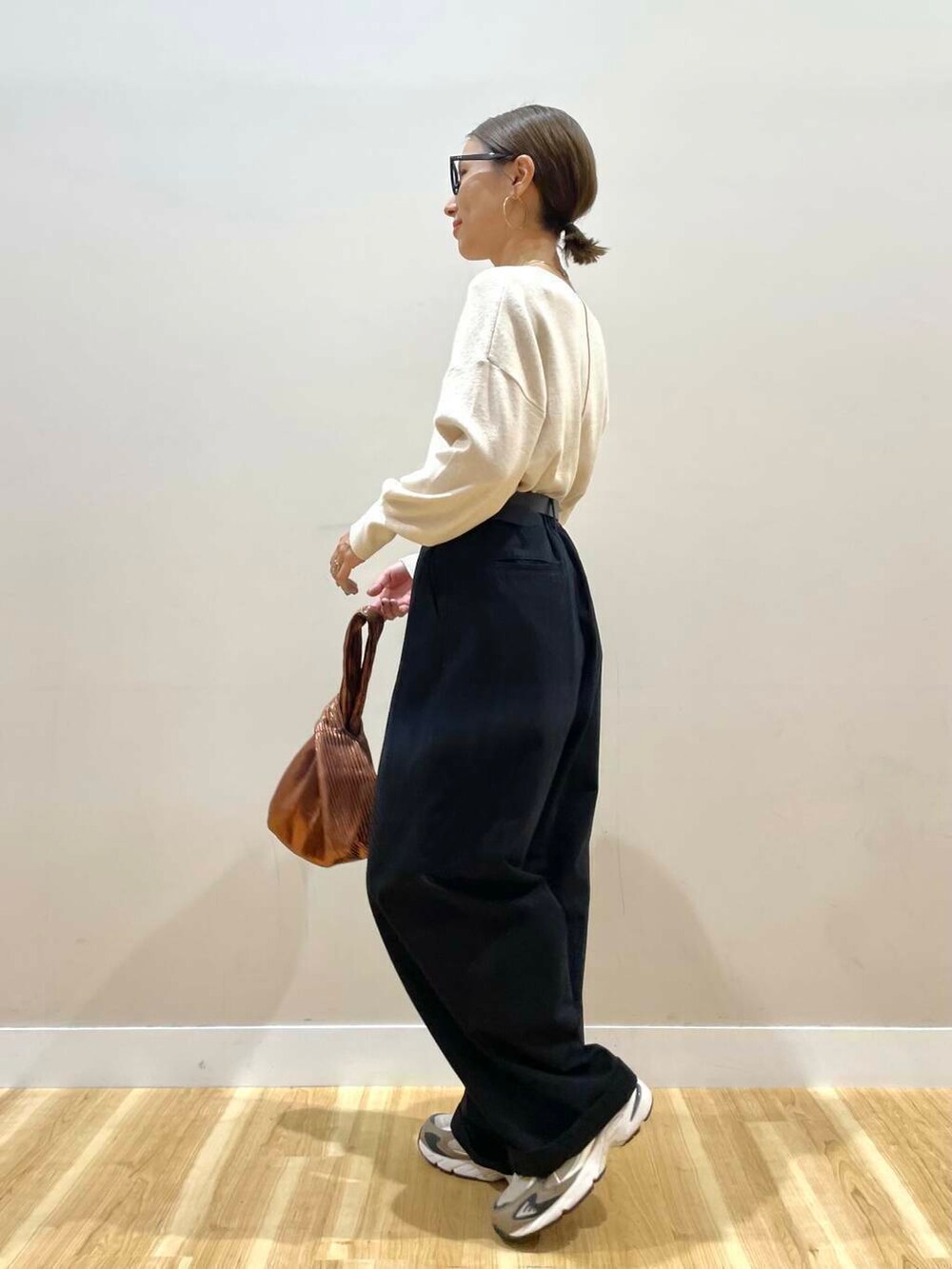 ホワイト系のニット/セーター、ブラウン系のハンドバッグ、ブラック系のその他アウターを着用したレディースの秋コーディネートの7枚目の写真