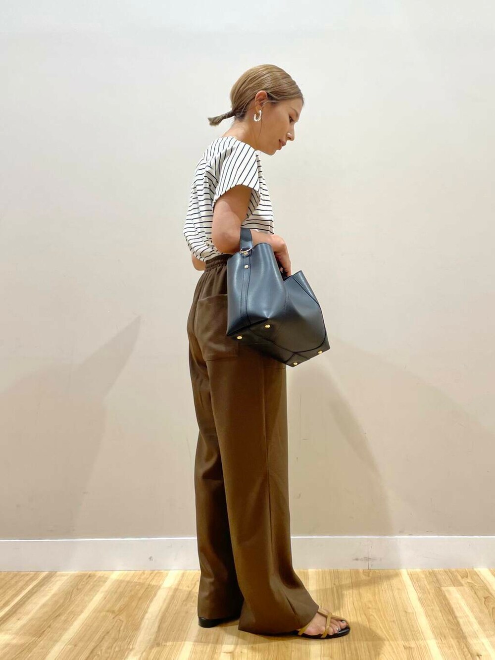 ブラウン系のサンダル、ホワイト系のTシャツ/カットソー、ブラック系のトートバッグを着用したレディースの夏コーディネートの2枚目の写真