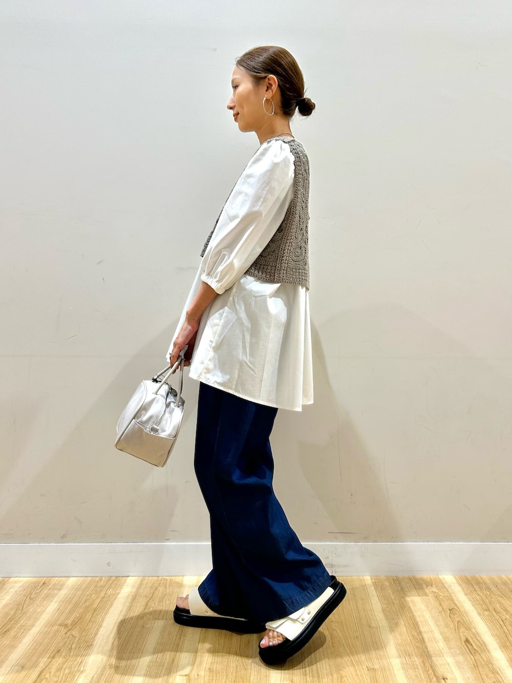 ベージュ系のシャツ/ブラウス、ブルー系のその他パンツ、ホワイト系のボストンバッグを着用したレディースの春コーディネートの4枚目の写真