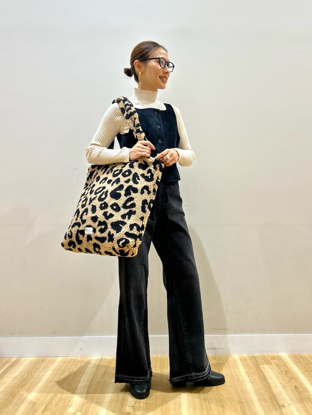 ホワイト系のニット/セーター、ブルー系のダウンベスト、ブラック系のデニムパンツを着用したレディースの秋コーディネートの5枚目の写真
