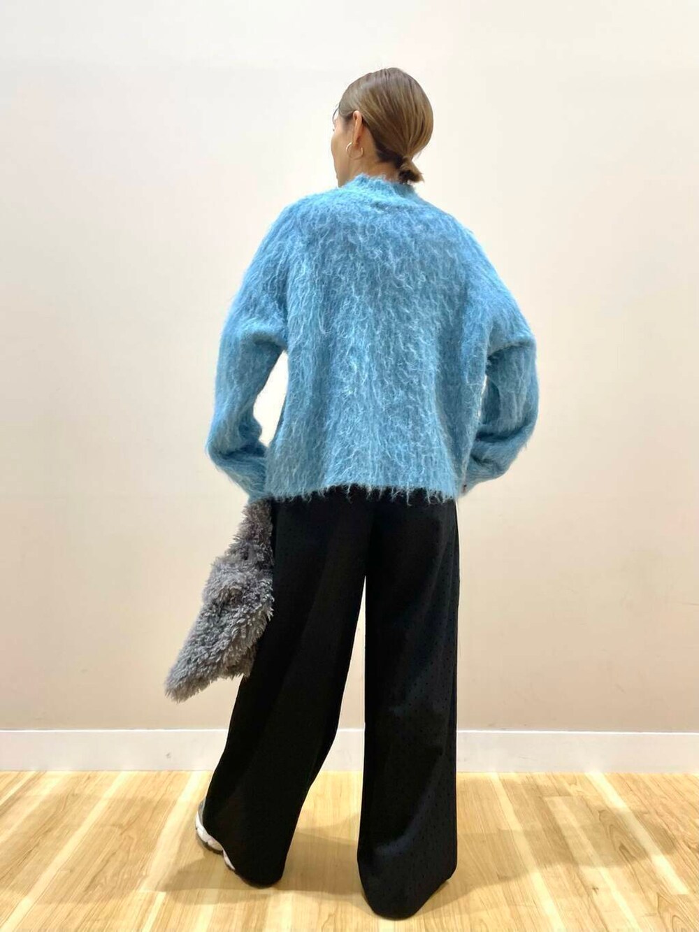 ブラック系のダウンジャケット/コート、ブルー系のニット/セーター、グレー系のハンドバッグを着用したレディースの冬コーディネートの9枚目の写真