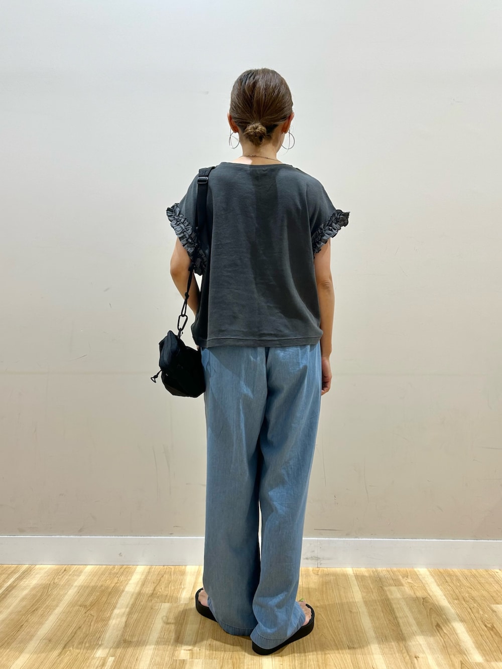 ブラック系のTシャツ/カットソー、ブルー系のデニムパンツ、ブラック系のショルダーバッグを着用したレディースの夏コーディネートの3枚目の写真