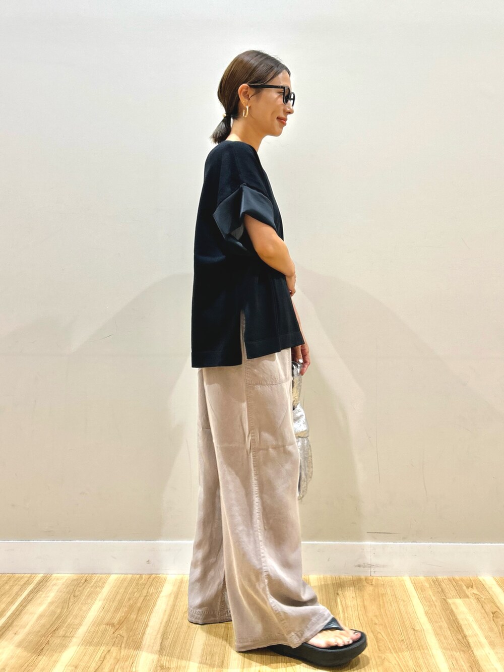 ブラック系のニット/セーター、グレー系のその他パンツ、シルバー系のハンドバッグを着用したレディースの秋コーディネートの4枚目の写真