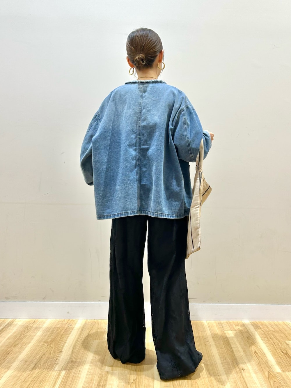 ブルー系のデニムジャケット、ホワイト系のベスト、ホワイト系のTシャツ/カットソーを着用したレディースの冬コーディネートの3枚目の写真