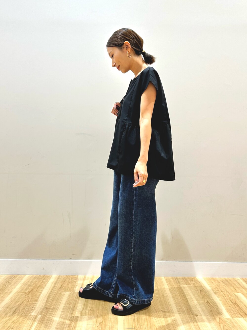 ブラック系のシャツ/ブラウス、ブルー系のデニムパンツを着用したレディースの秋コーディネートの2枚目の写真