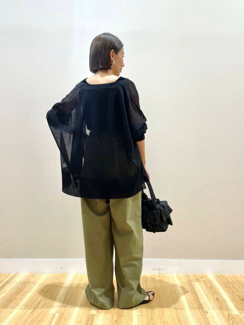 ブラック系のショルダーバッグ、ブラック系のカーディガン/ボレロ、ブラック系のタンクトップを着用したレディースの秋コーディネートの3枚目の写真