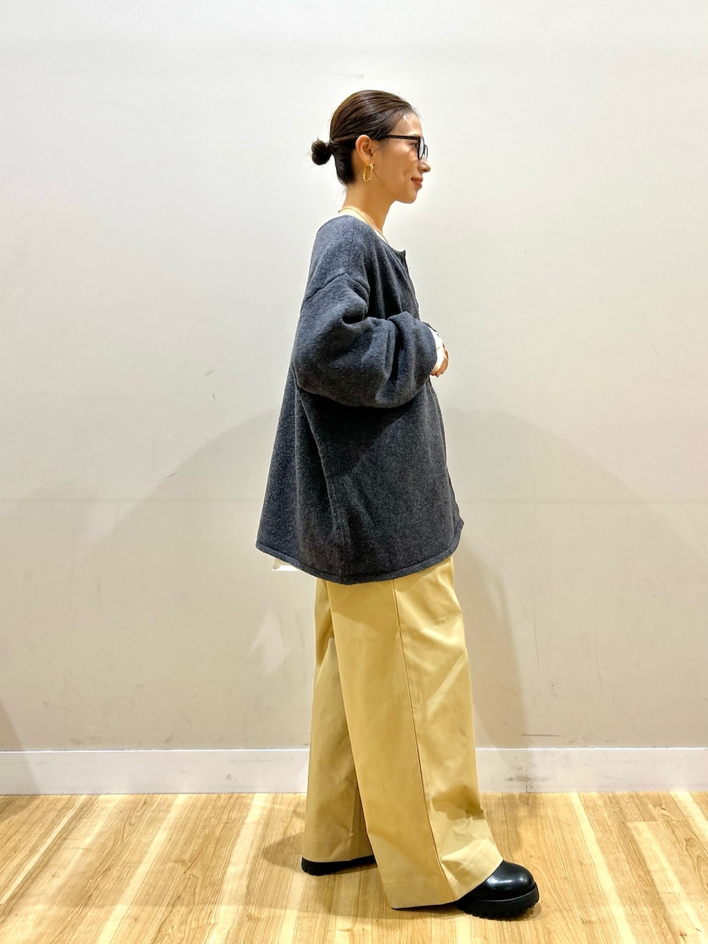 グレー系のニット/セーター、ホワイト系のシャツ/ブラウス、ベージュ系のその他パンツを着用したレディースの秋コーディネートの4枚目の写真