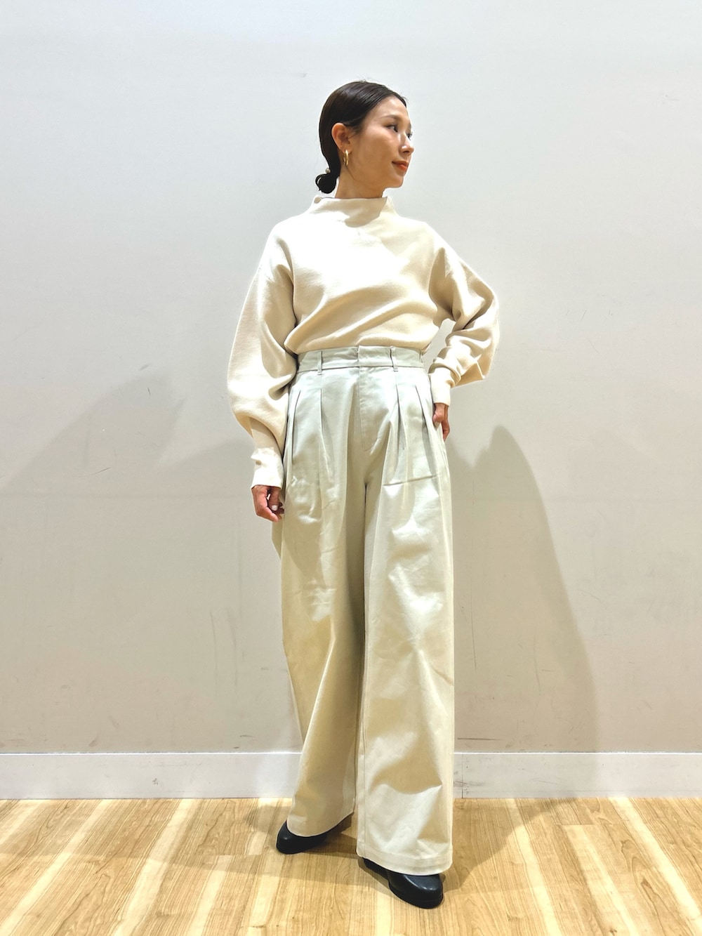 ブルー系のダウンジャケット/コート、ホワイト系のニット/セーター、ベージュ系のその他パンツを着用したレディースの冬コーディネートの4枚目の写真