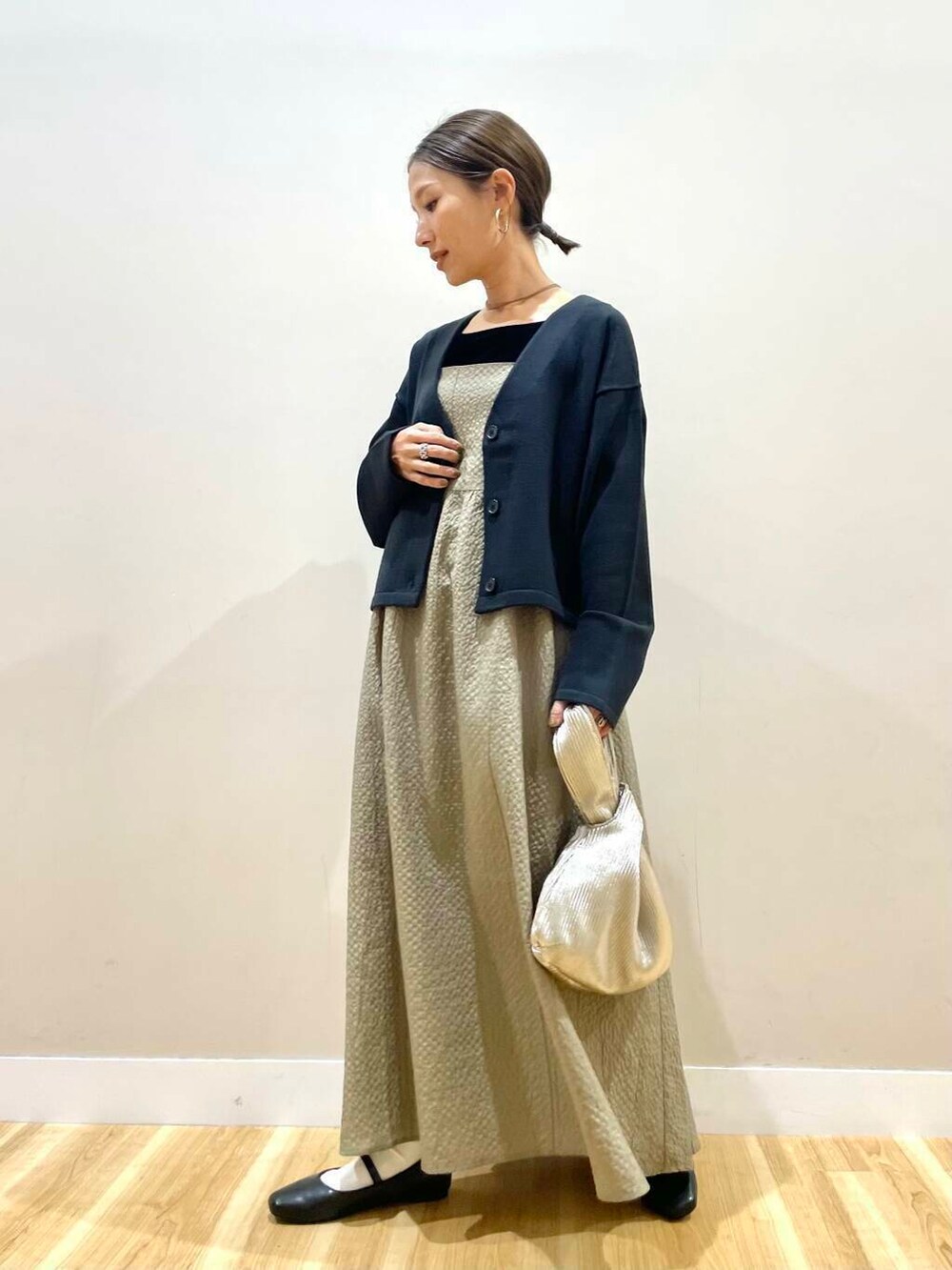 ブラック系のパンプス、ゴールド系のハンドバッグ、ブラック系のタンクトップを着用したレディースの秋コーディネートの5枚目の写真