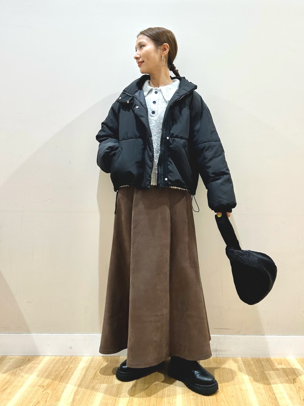 ブラック系のダウンジャケット/コート、グレー系のニット/セーター、ブラウン系のスカートを着用したレディースの秋コーディネートの9枚目の写真