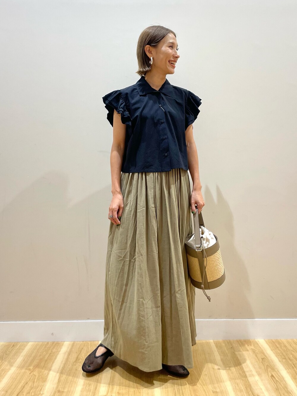 イエロー系のスカート、ブラック系のシャツ/ブラウスを着用したレディースの夏コーディネートの5枚目の写真