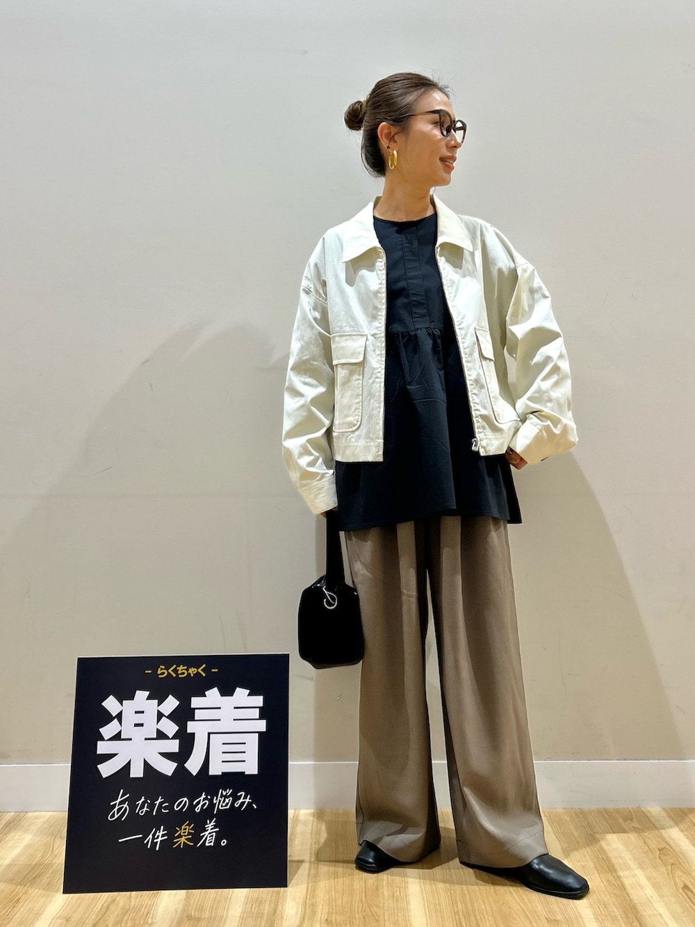 ホワイト系のブルゾン、ブラック系のシャツ/ブラウス、ブラック系のトートバッグを着用したレディースの春コーディネートの4枚目の写真