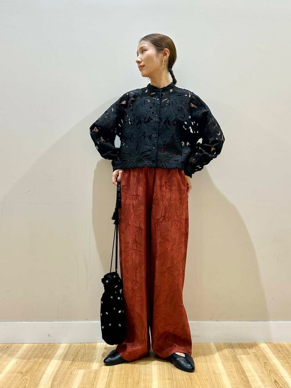 ブラック系のショルダーバッグ、オレンジ系のその他パンツ、ブラック系のシャツ/ブラウスを着用したレディースの春コーディネートの4枚目の写真