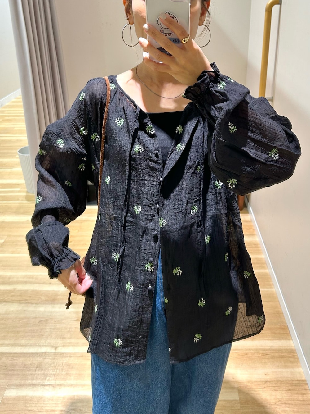 ブラック系のシャツ/ブラウス、ブルー系のデニムパンツ、ブラウン系のショルダーバッグを着用したレディースの春コーディネートの4枚目の写真