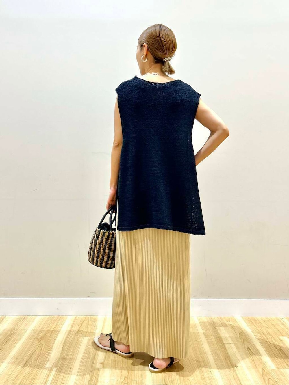 ベージュ系のタンクトップ、ブラック系のハンドバッグ、ブラック系のサンダルを着用したレディースの夏コーディネートの4枚目の写真