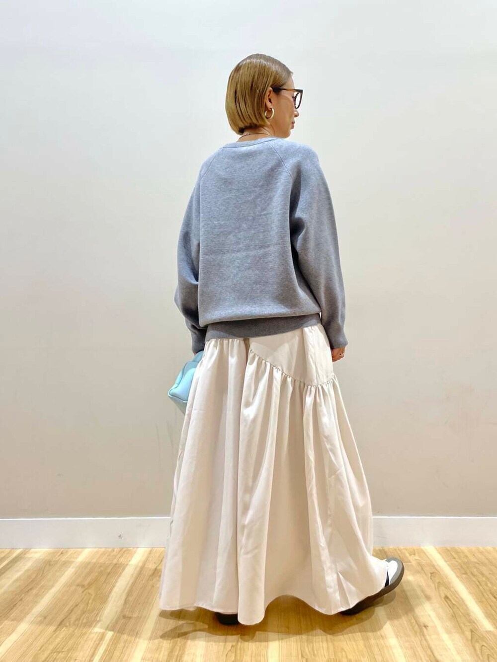 ブルー系のハンドバッグ、グレー系のワンピースを着用したレディースの秋コーディネートの4枚目の写真