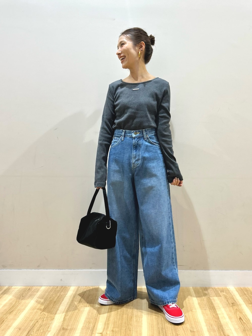 グレー系のステンカラーコート、グレー系のTシャツ/カットソー、ブルー系のデニムパンツを着用したレディースの春コーディネートの5枚目の写真