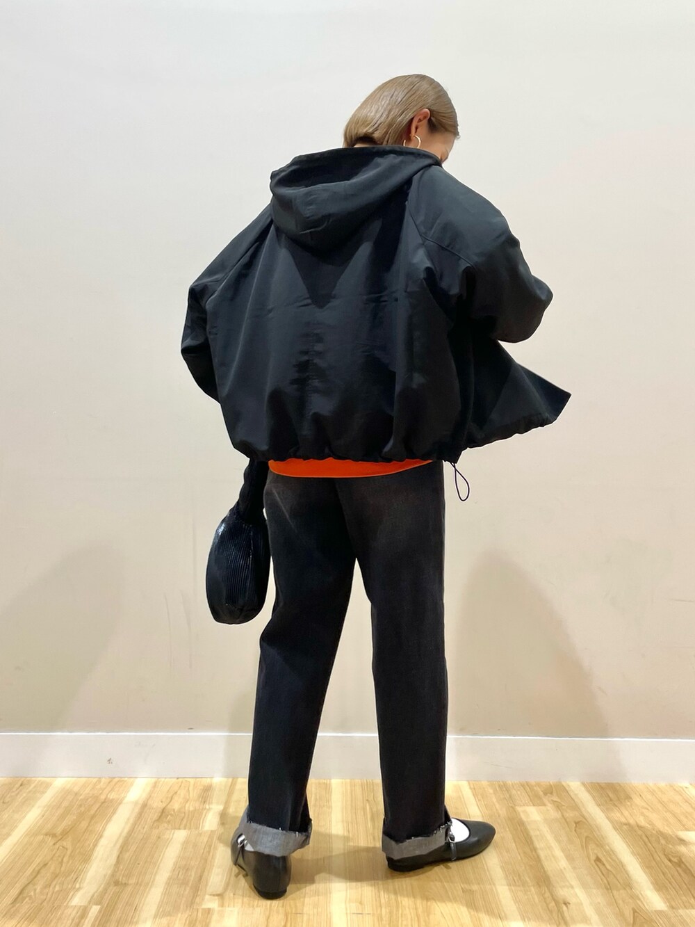 ブラック系のマウンテンパーカー、オレンジ系のスウェット、ブラック系のその他パンツを着用したレディースの秋コーディネートの5枚目の写真