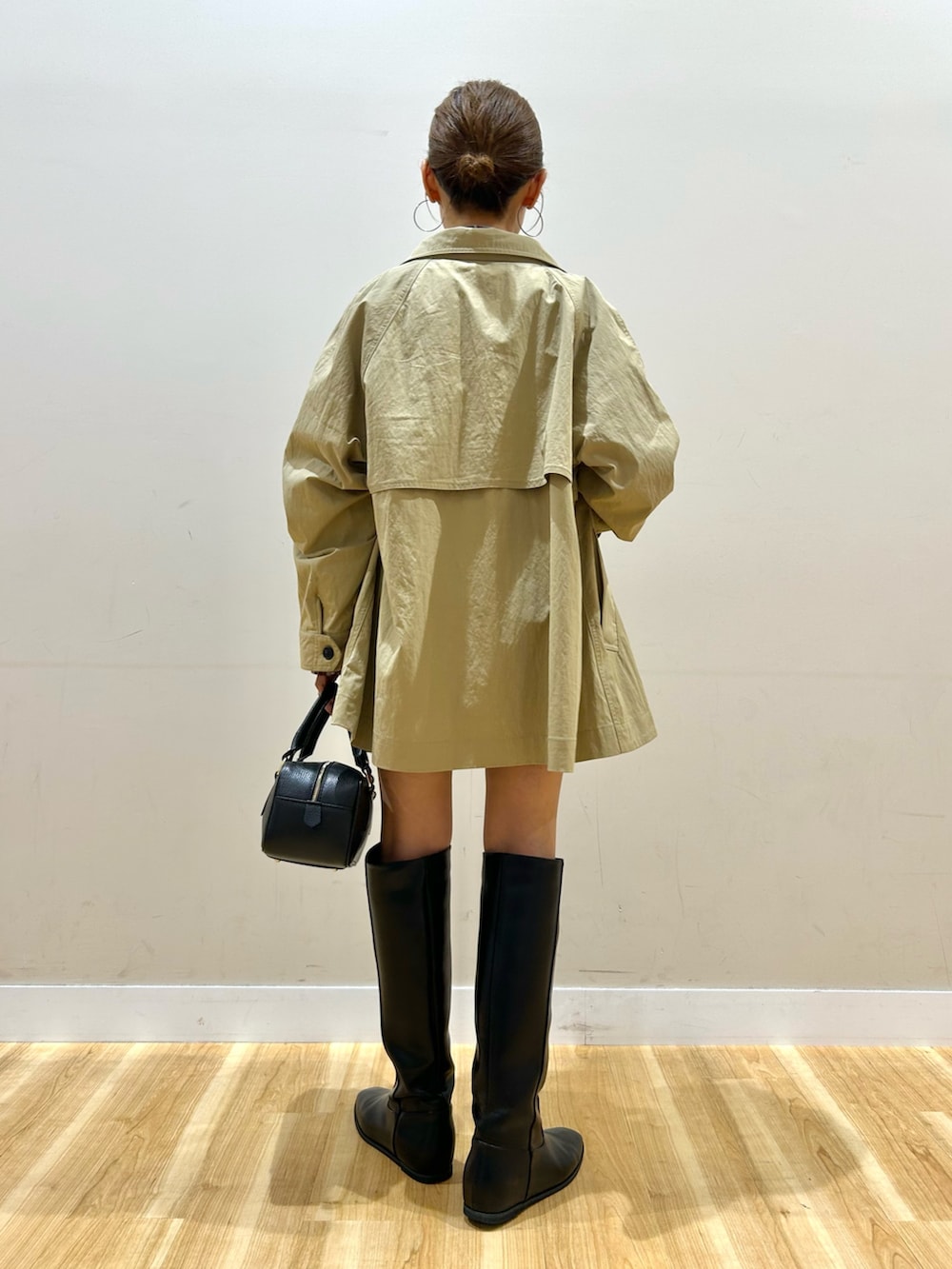 ベージュ系のその他アウター、レッド系のシャツ/ブラウス、ブラック系のハンドバッグを着用したレディースの秋コーディネートの3枚目の写真