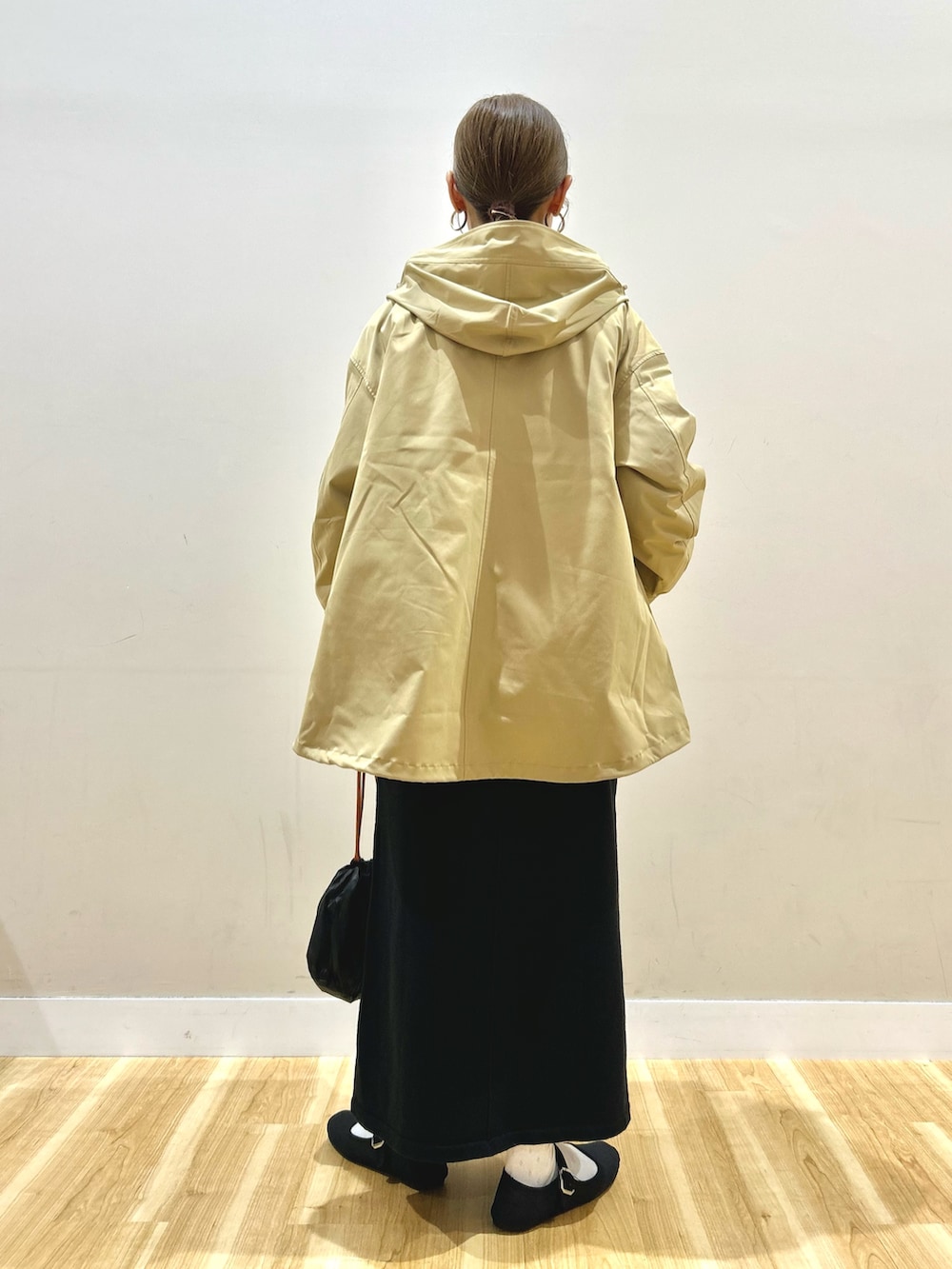 ベージュ系のダウンジャケット/コート、グレー系のニット/セーター、ブラック系のスカートを着用したレディースの秋コーディネートの3枚目の写真