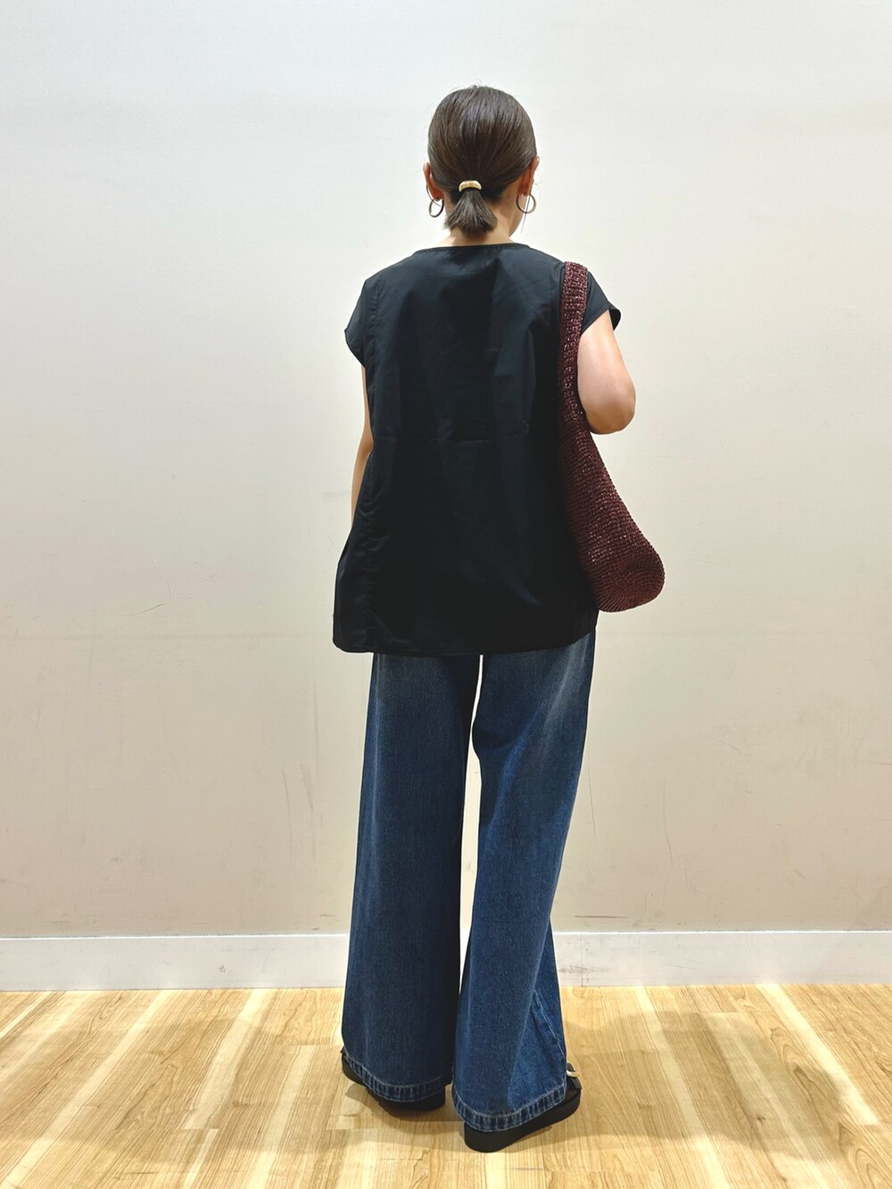 ブラック系のシャツ/ブラウス、ブルー系のデニムパンツを着用したレディースの秋コーディネートの3枚目の写真