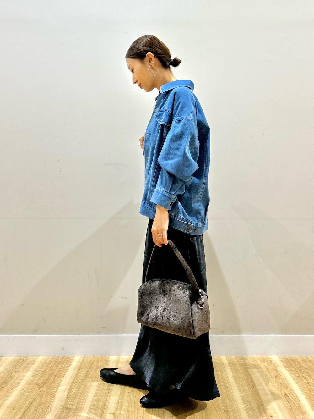 ブルー系のカバーオール、ホワイト系のTシャツ/カットソー、ブラック系のスカートを着用したレディースの秋コーディネートの4枚目の写真