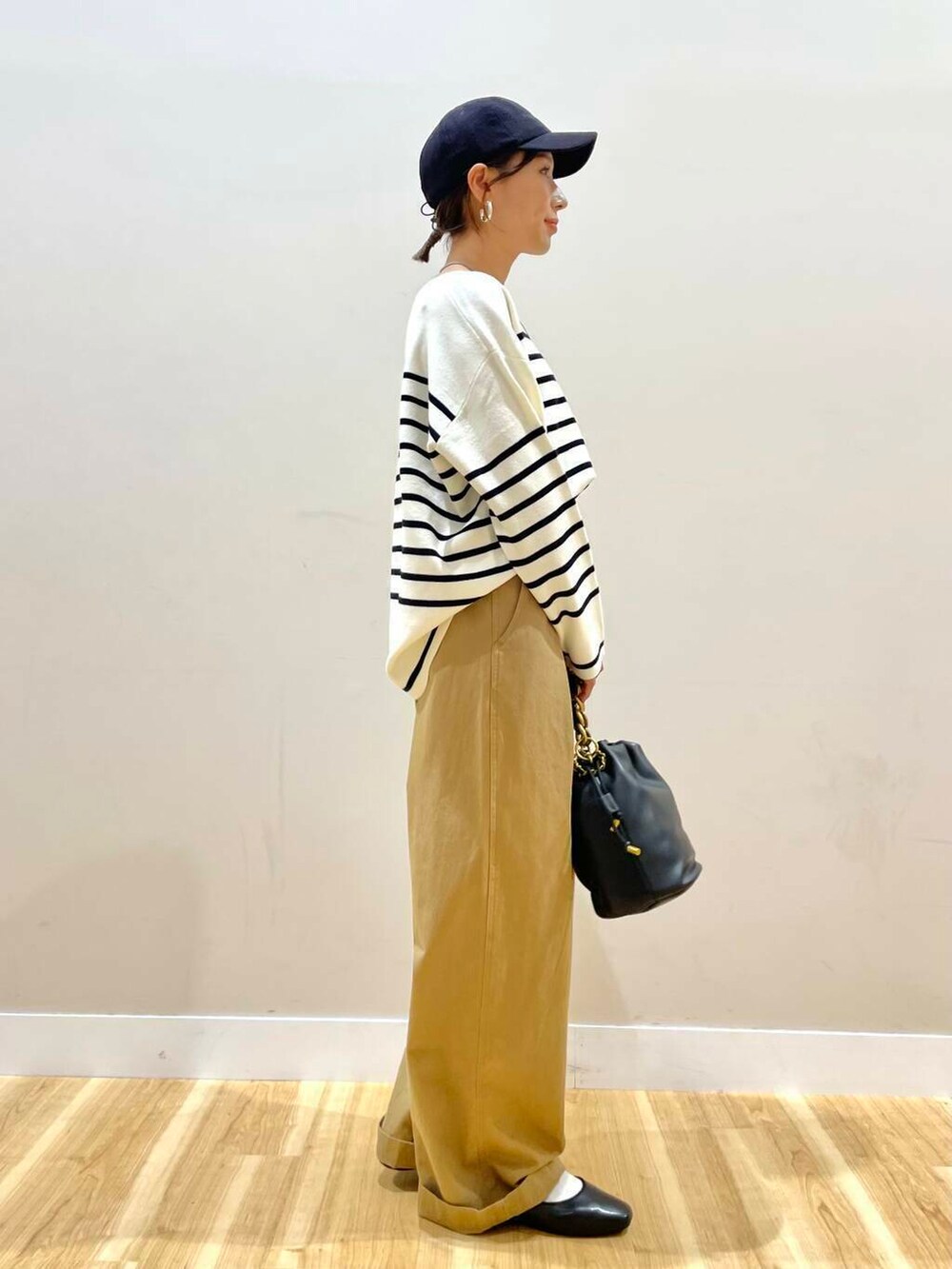 ブラック系のパンプス、ブラック系のショルダーバッグ、ブラック系のニット/セーターを着用したレディースの秋コーディネートの3枚目の写真