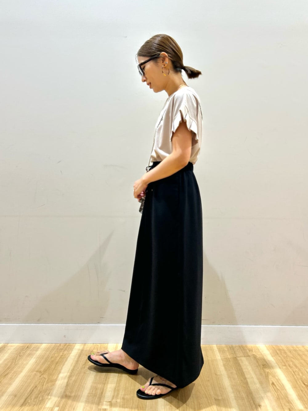ベージュ系のTシャツ/カットソー、ブラック系のスカート、その他のショルダーバッグを着用したレディースの夏コーディネートの2枚目の写真