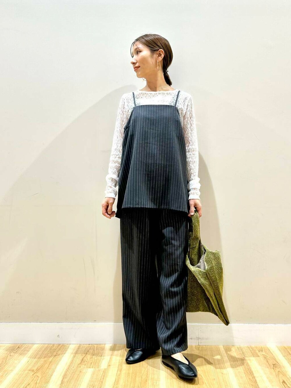 ゴールド系のトートバッグ、グレー系のセットアップ、ホワイト系のTシャツ/カットソーを着用したレディースの春コーディネートの5枚目の写真